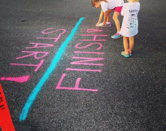 girl writing on the ground using a spray an