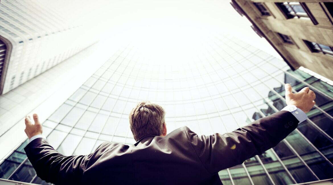 low-angle photography of man in the middle of buidligns