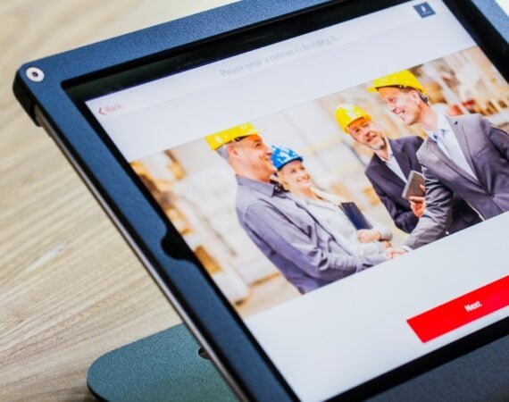 iPad with four business persons shaking hands display