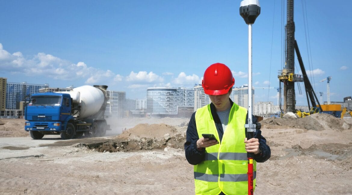 man in black and yellow jacket wearing red helmet holding black and white stick
