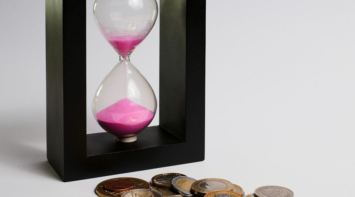 clear hour glass with coins