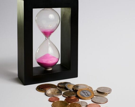 clear hour glass with coins