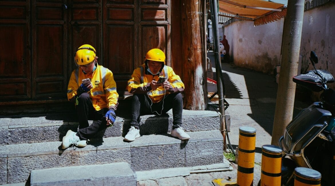 two people in yellow jackets sitting on steps