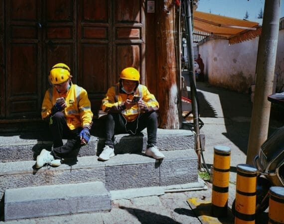two people in yellow jackets sitting on steps